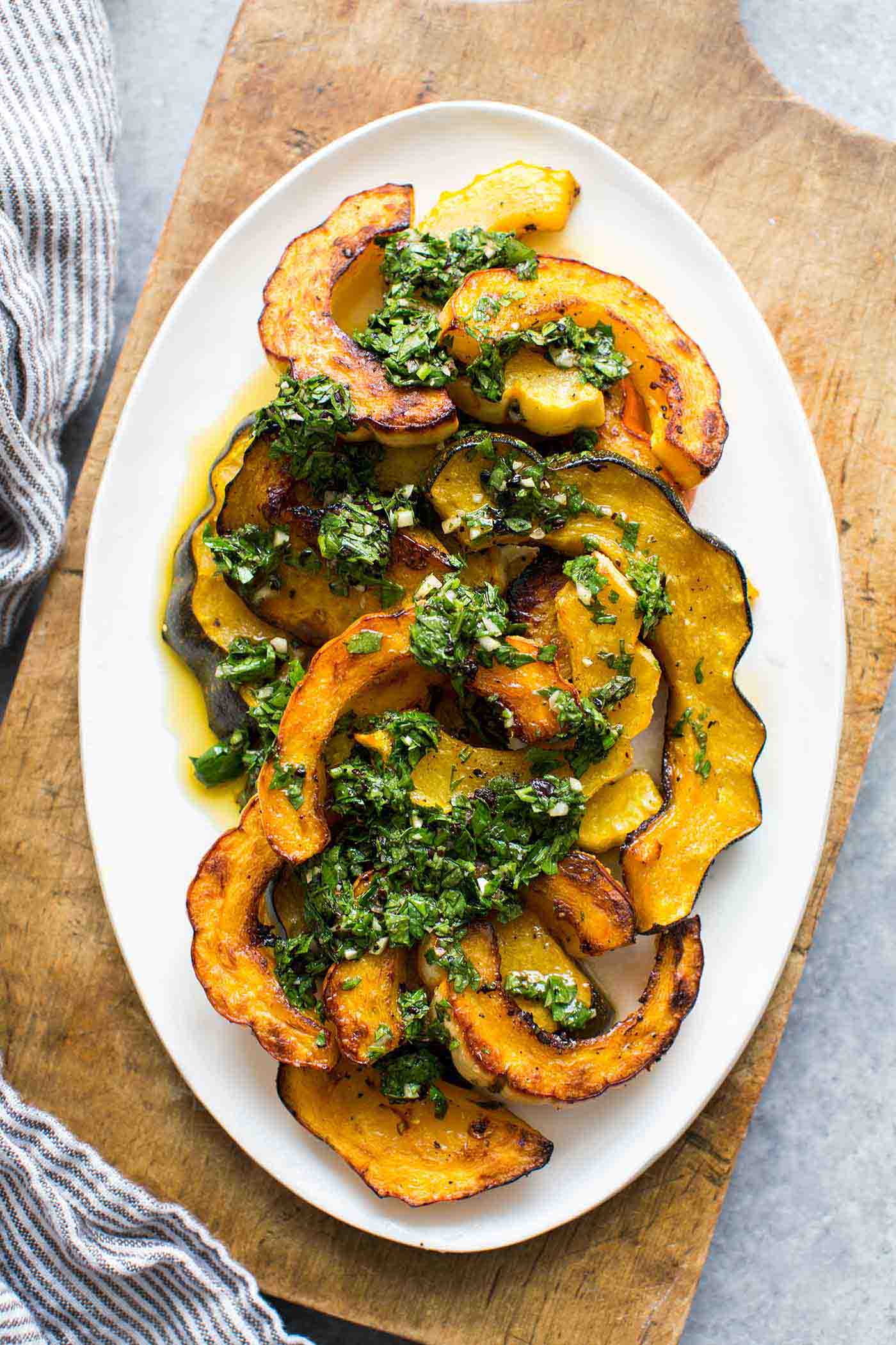 Vegan Roasted Winter Squash with Cilantro Chimichurri // Winter dinner parties don't have to ruin your diet. You can serve a beautiful plate of this tasty squash recipe and get everyone to eat healthy with you. | The Green Loot #vegan #cleaneating #weightloss
